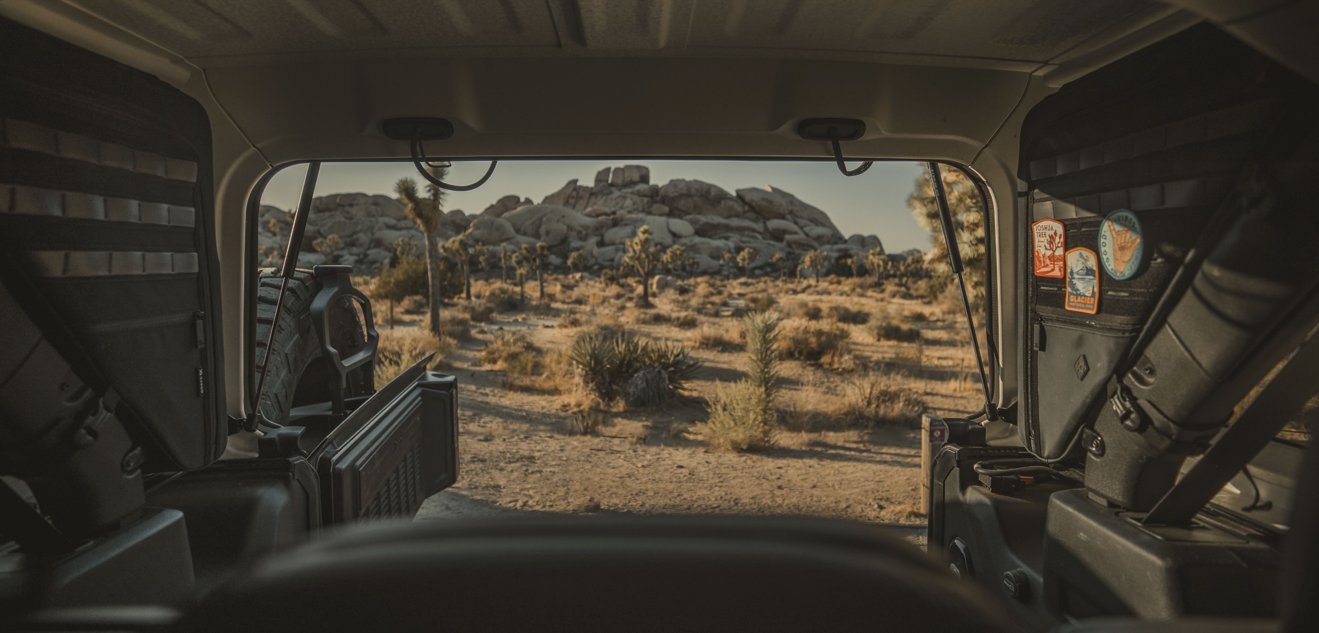 View out the back of a Jeep Wrangler with Gama bags mounted on both sides, Joshua Tree desert beyond